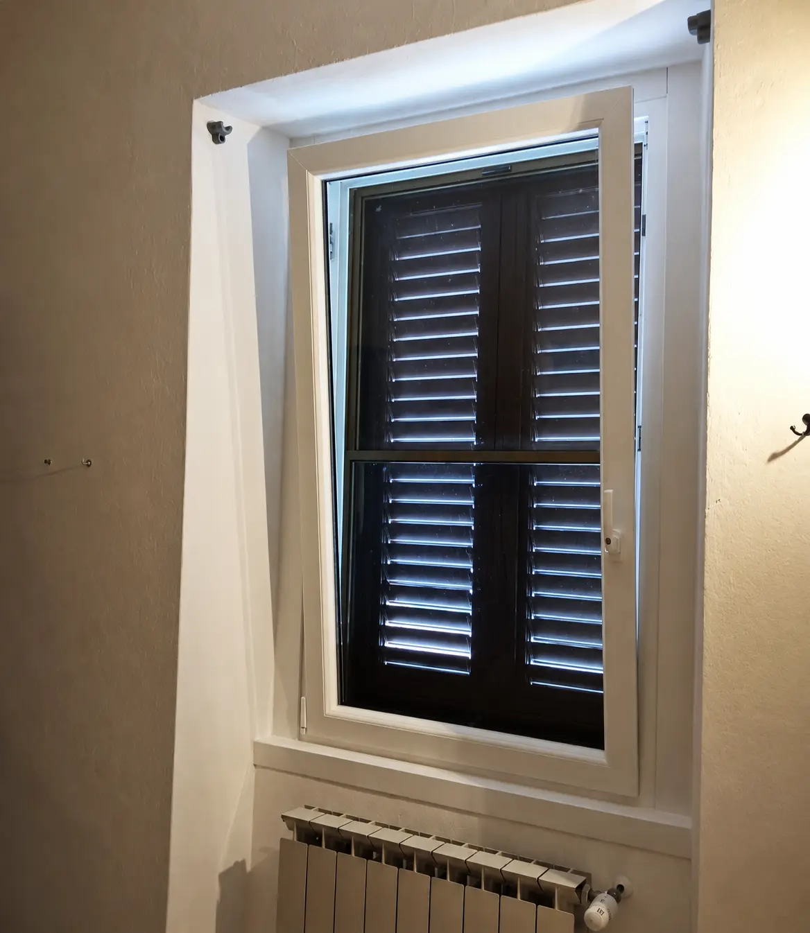 Finestra con supporti personalizzati per l'asta della tenda