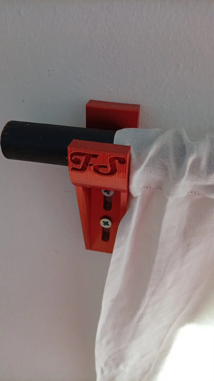 Supporto ramato per asta da tenda installato sulla parete
