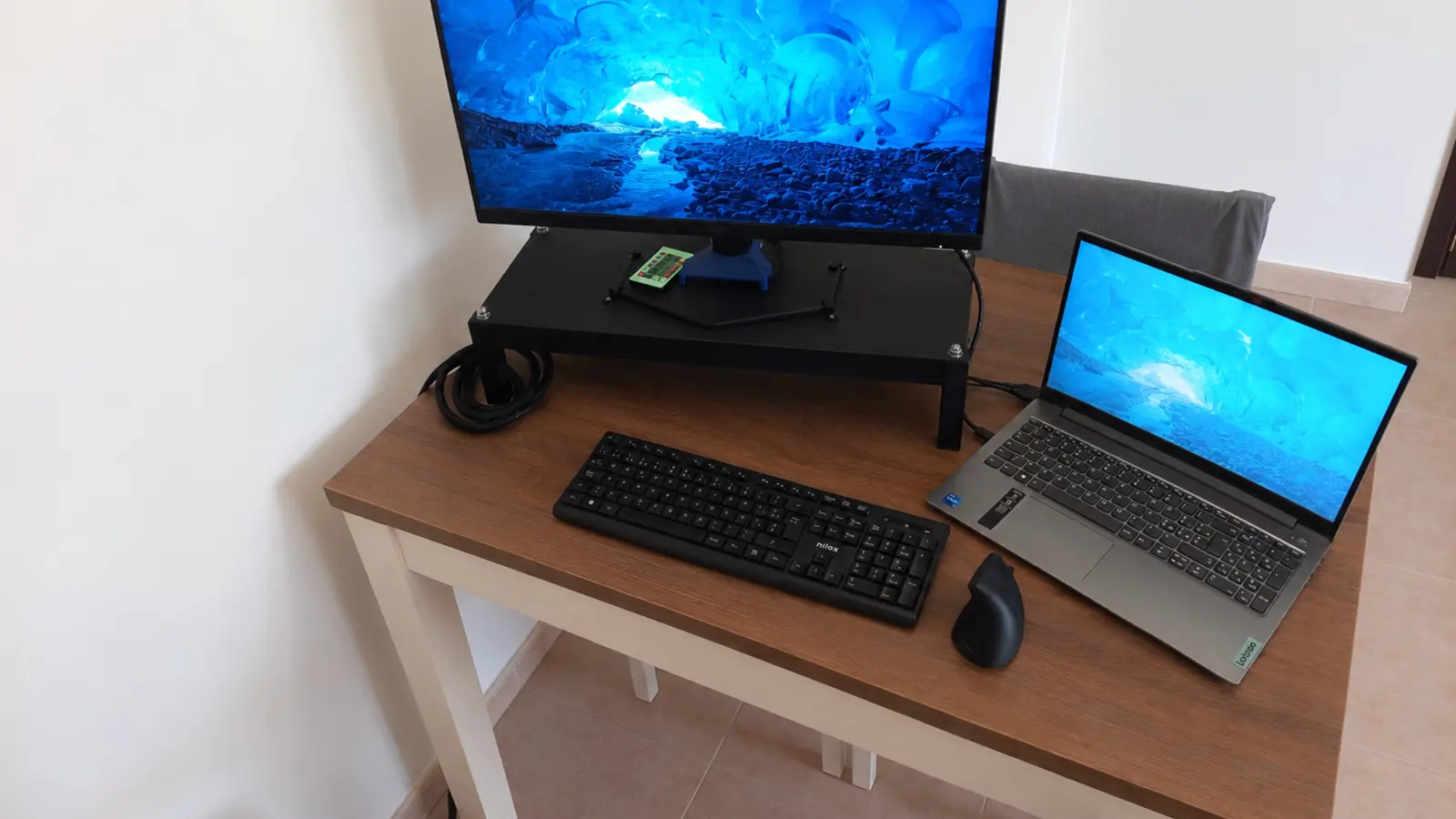 Workstation domestica con monitor esterno, notebook, tastiera e supporto rialzato personalizzato