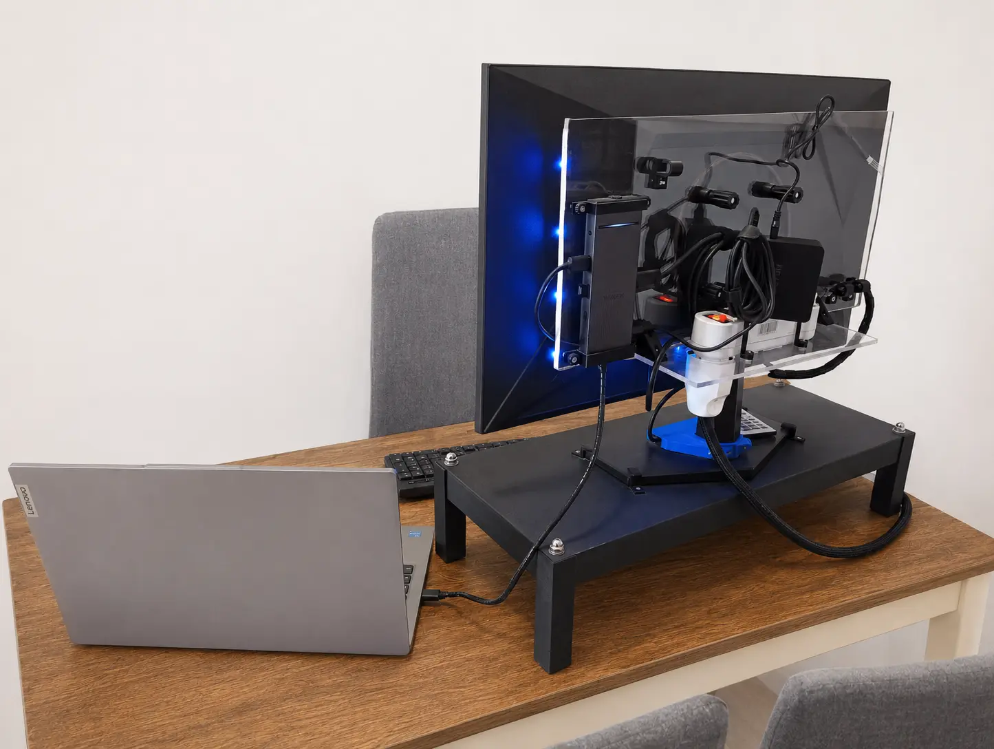 Parte posteriore di una workstation con monitor, docking station, alimentazione e supporti in acrilico