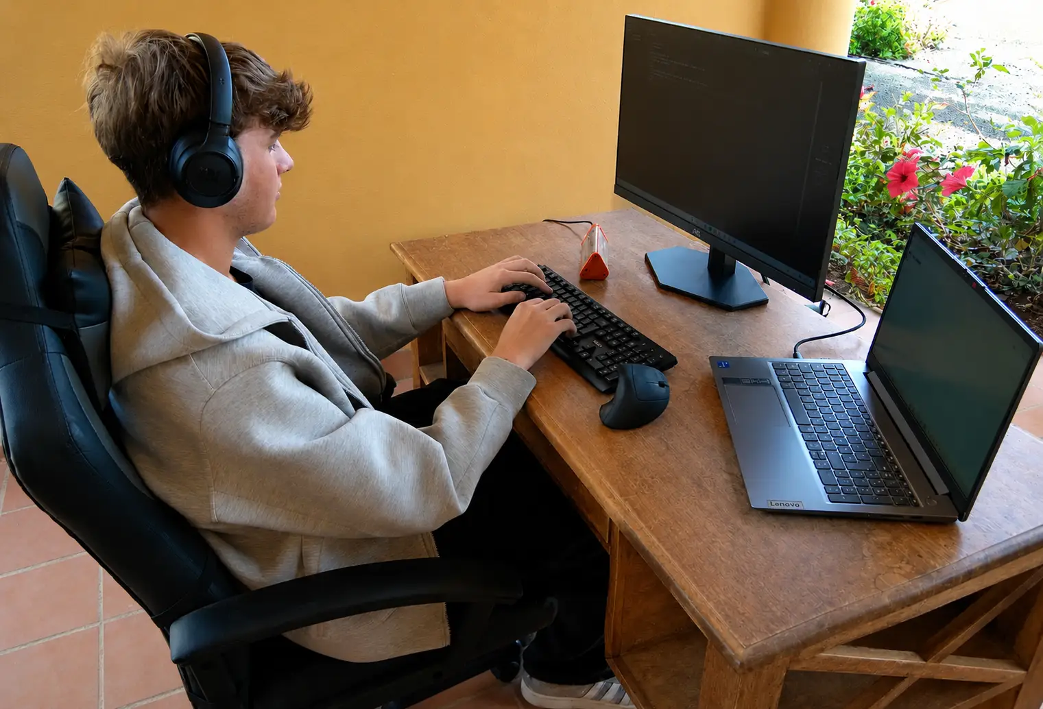 Vista laterale di una workstation mobile con monitor, notebook e accessori
